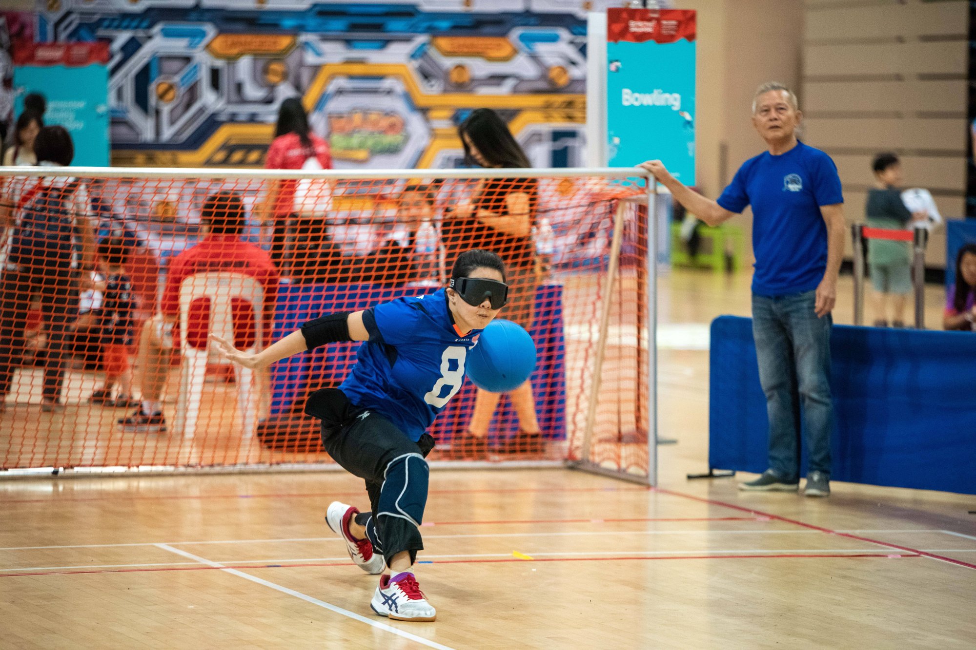 Photo of a Goal Ball female player starting to toss the ball