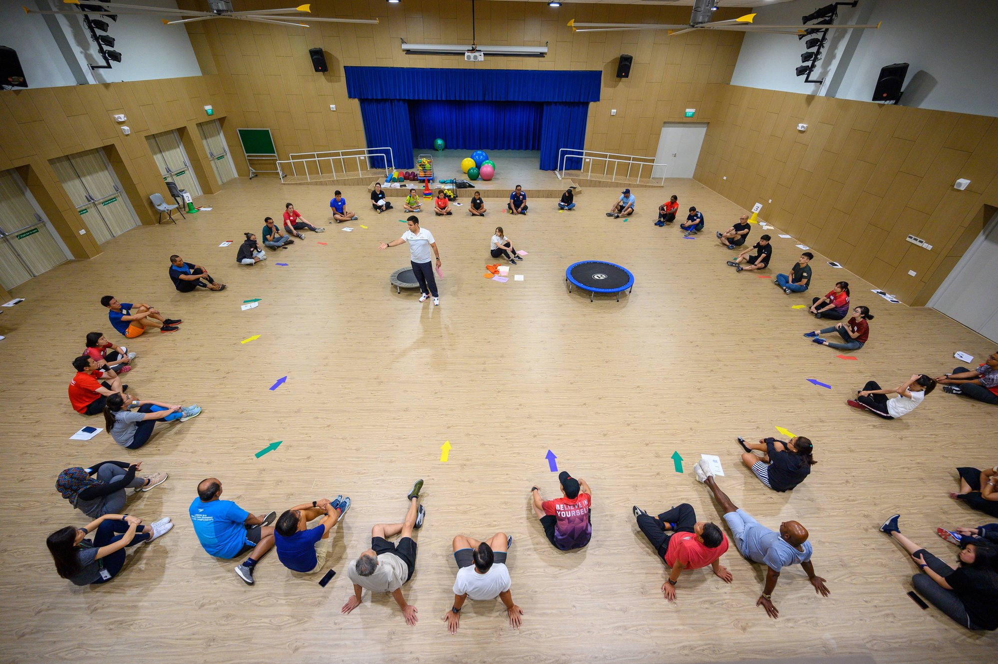 Group of participants sitting on the floor listening to course facilitator