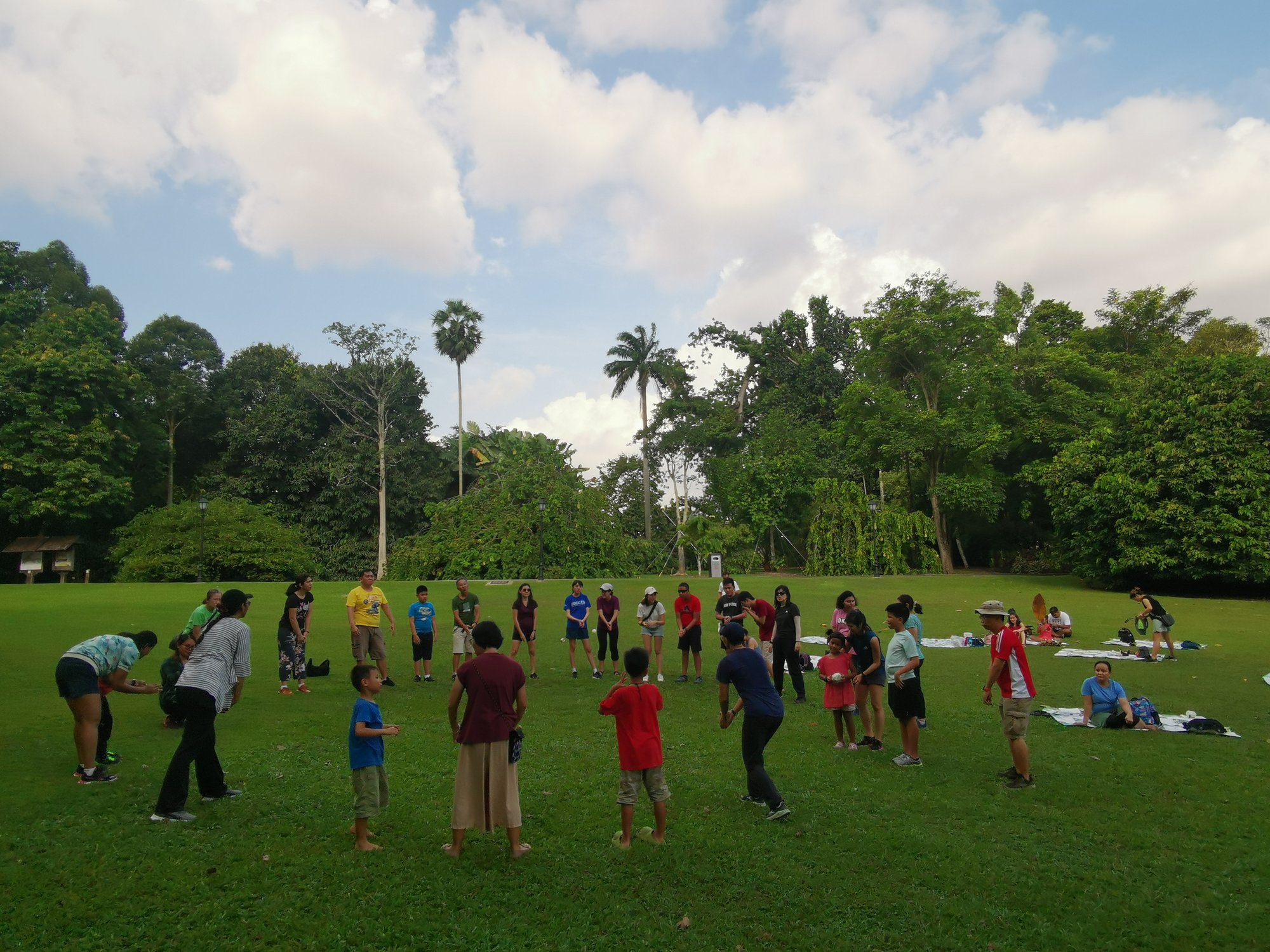 Photo of a group of about thirty persons enjoying games in a park